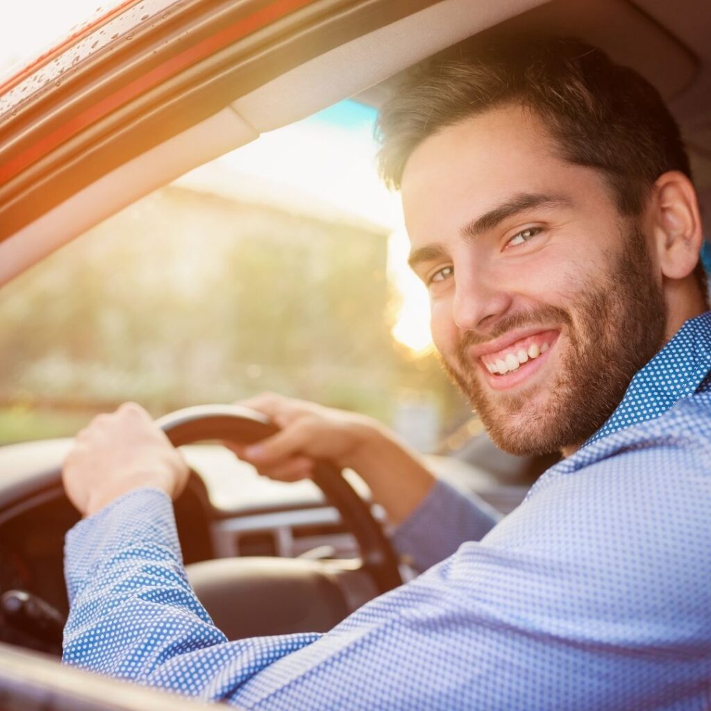 Un hombre feliz conduciendo un coche
