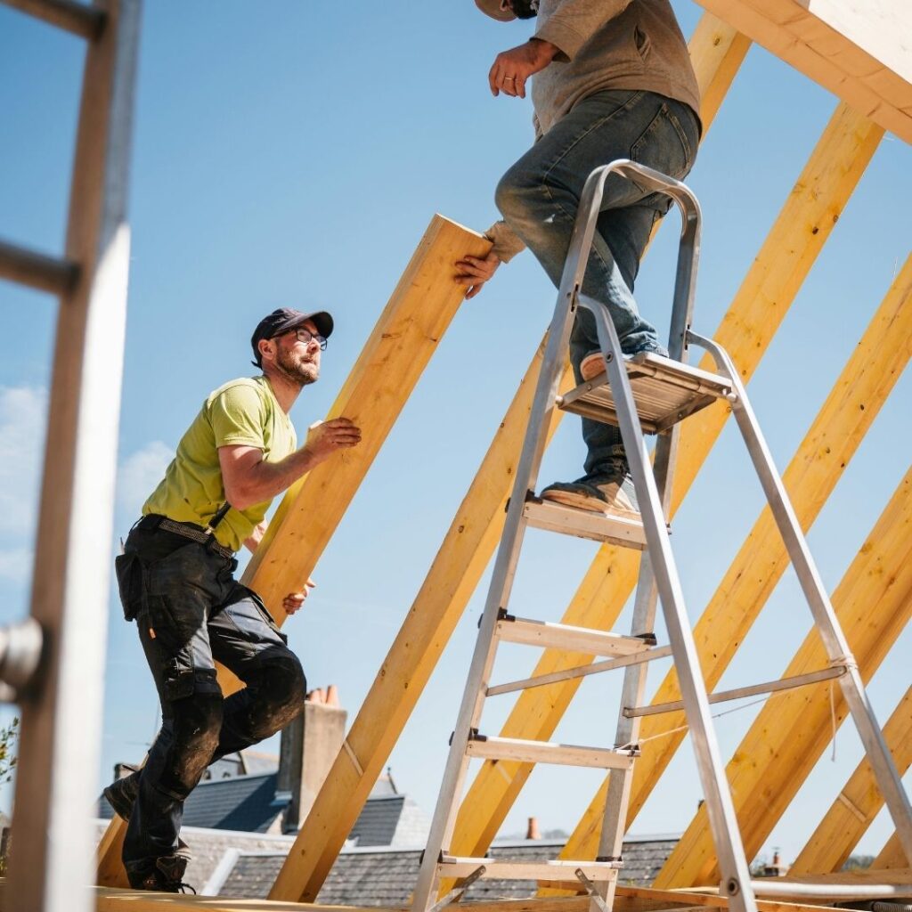 construction workers building frame of house 