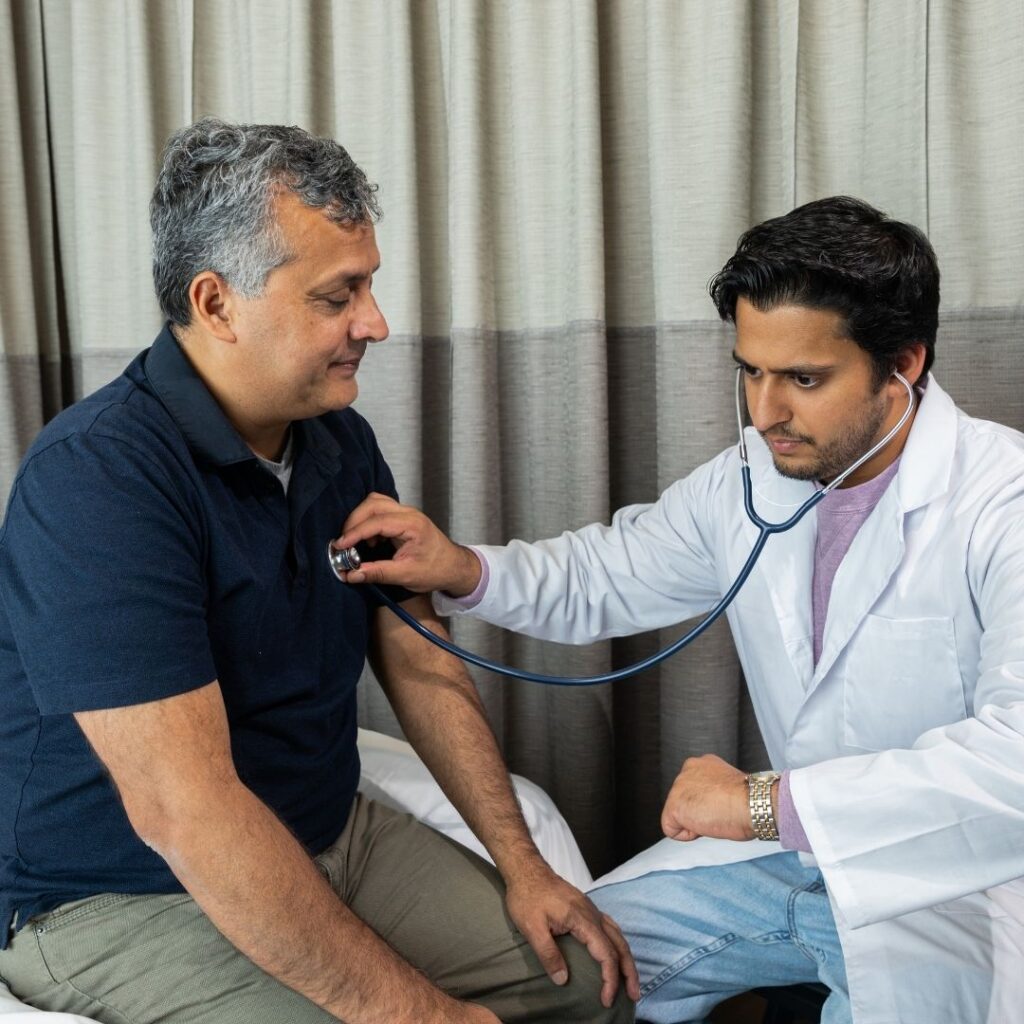 doctor listening to man's heart 
