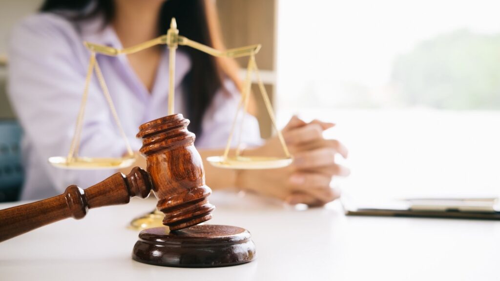 person sitting at desk with wooden gavel in front of them