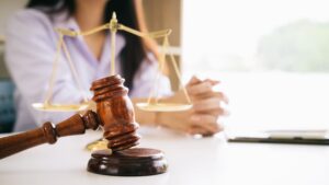 person sitting at desk with wooden gavel in front of them