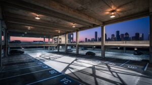 Multi-level concrete parking garage structure with overhead lighting in Houston.