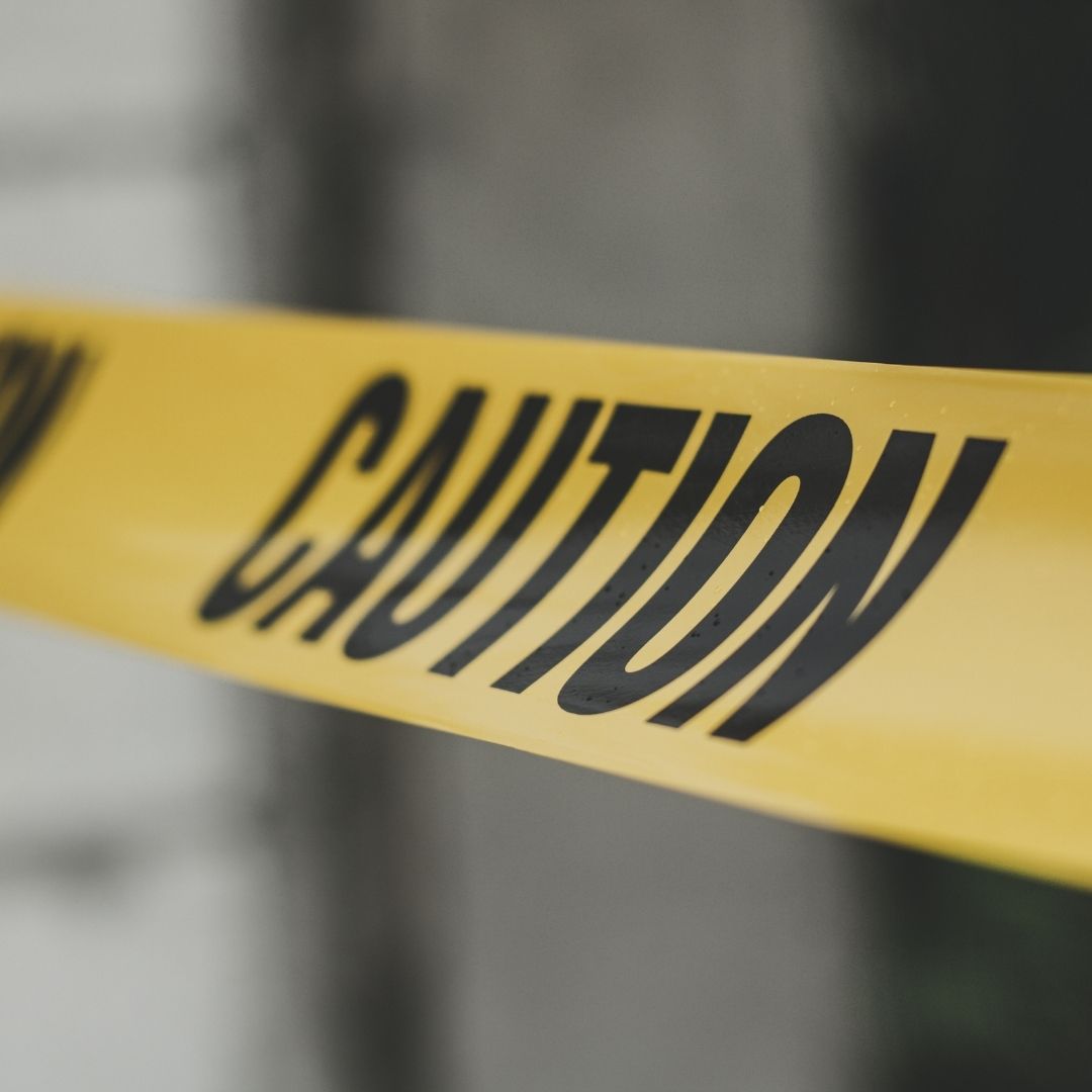 Yellow caution tape stretched across a commercial property scene.