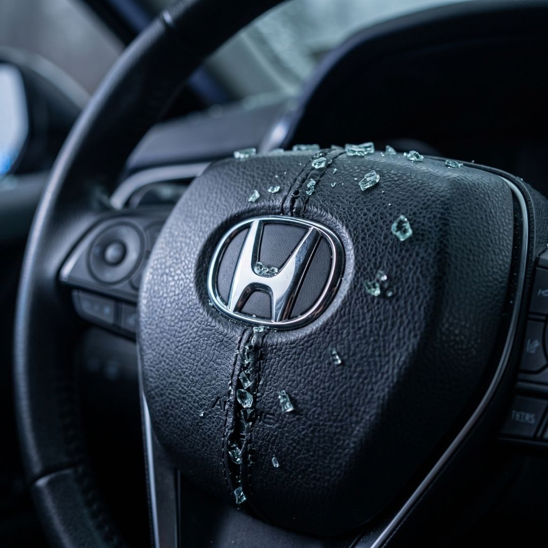 Steering wheel center cap showing the airbag seam compartment after an impact.